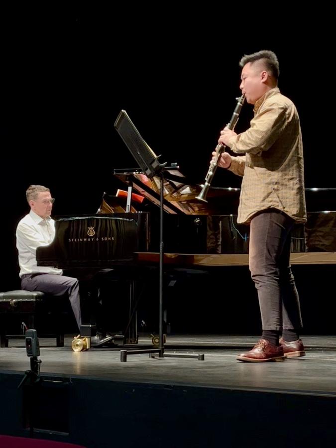 Person sitting at the piano and person playing the clarinet