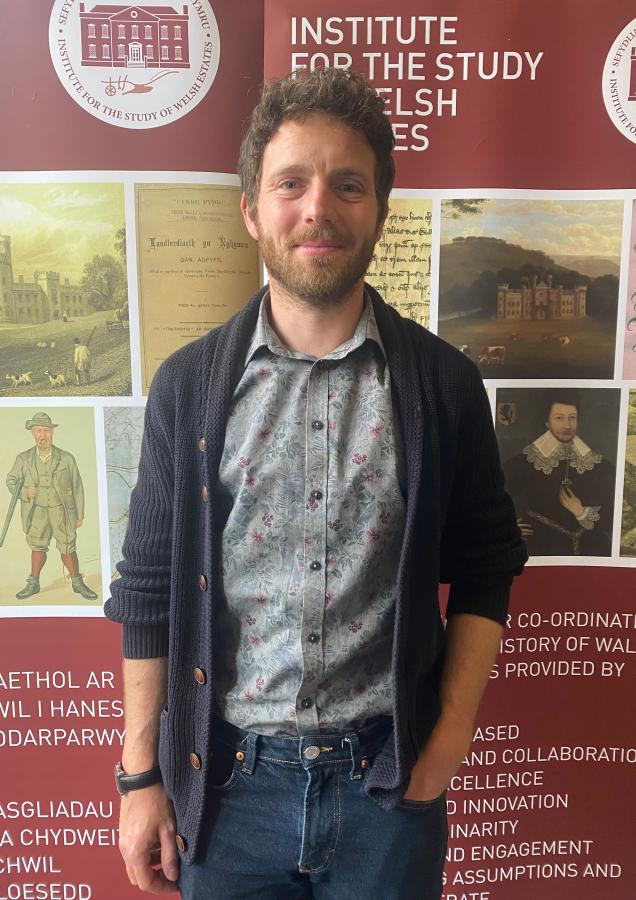Llun o ymchwilydd doethurol Alex