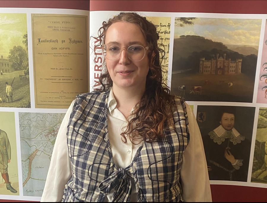 Doctoral researcher Bethan in front of an ISWE banner.