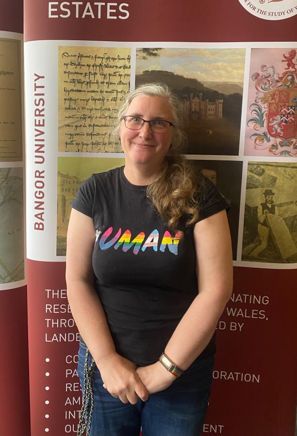 Doctoral Researcher Anna stands in front of an ISWE banner.