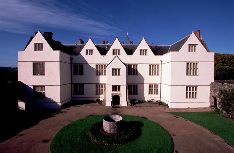 Photograph a symmetrical manor house called St Fagans Castle, which is rendered and lime washed.