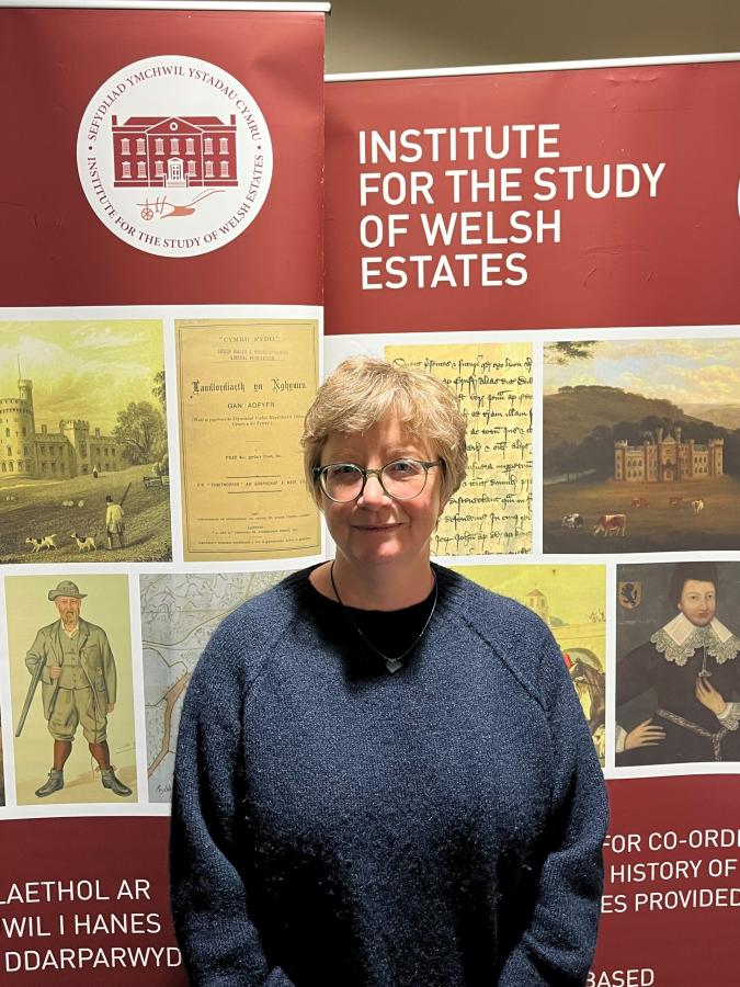 A photograph of doctoral student Hannah Jones standing in front of the ISWE banner