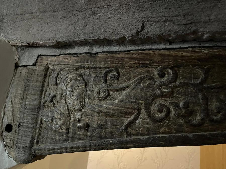 Photograph of the spandrel of a wooden doorway, with decorative carvings