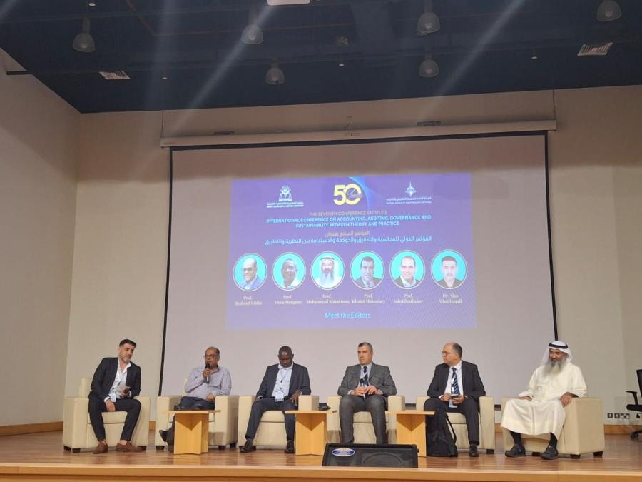 Prof Hussainey on stage with colleagues at the editors session in April 2025