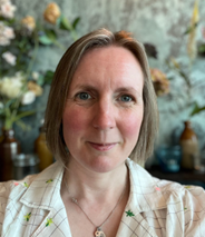 In image of a woman with medium length hair wearing a white blouse