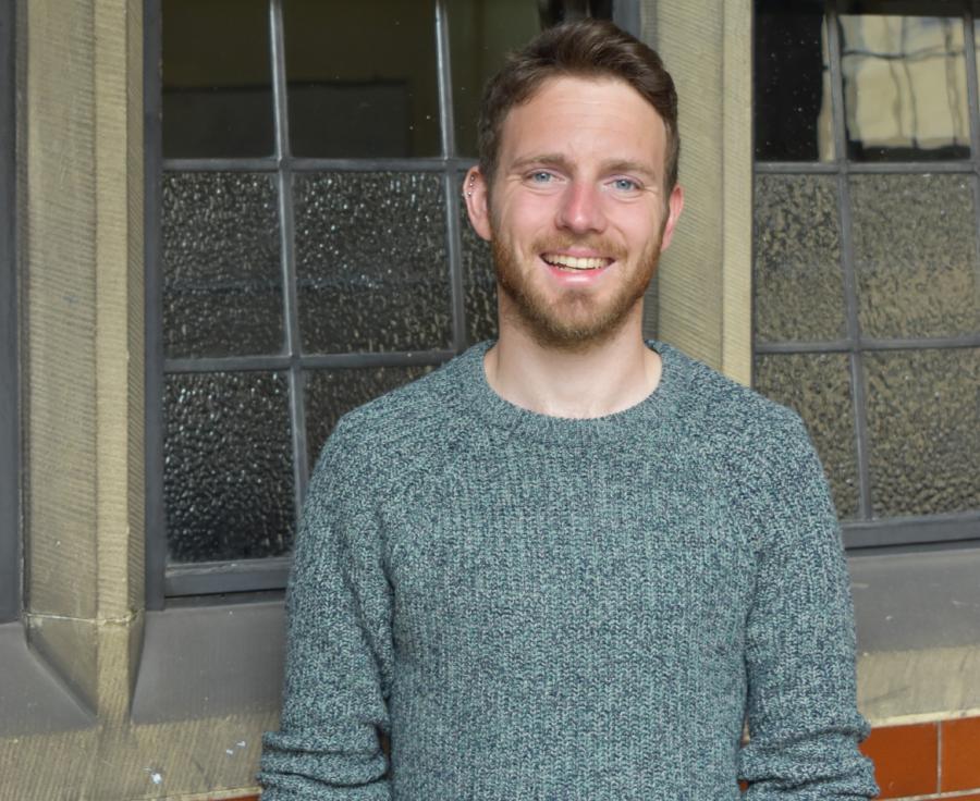 a man standing outside a University building
