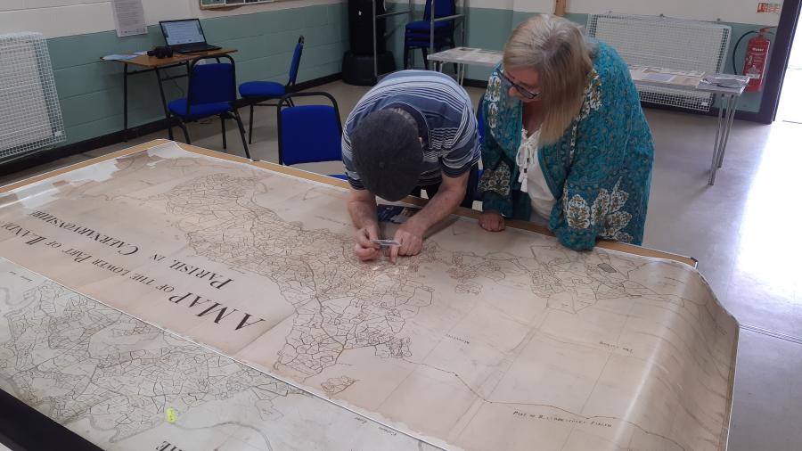 Two people carefully inspecting a large map
