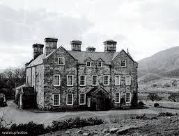 Black and white photograph of a country house in a mountainous landscape