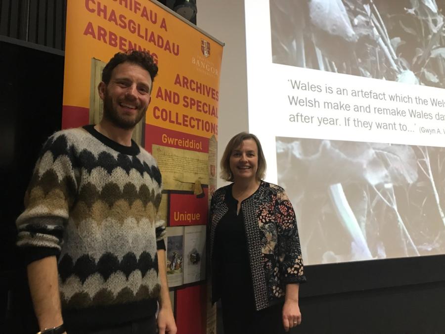 Two people stand either side of a yellow and red banner which reads 'Archives and Special Collections' 
