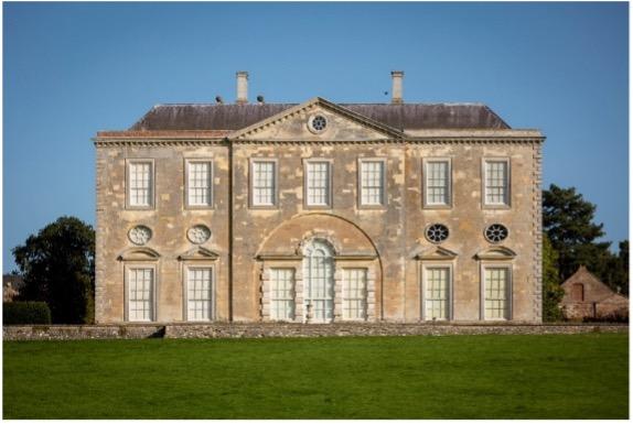 Photograph of a symmetrical house with a honey-coloured stone. 