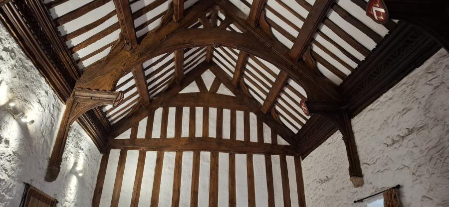 Ffotograff yn edrych i fyny ar do pren addurnedig.