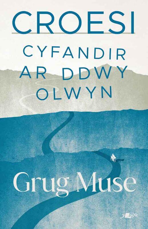Book cover with the Welsh title “Croesi: Cyfandir Ar Ddwy Olwyn” by Grug Muse. The design shows layered hills and a winding blue road leading into the distance. A small cyclist icon appears on the road. The background uses muted blue and cream tones.
