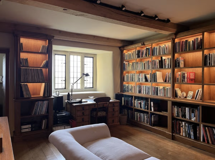 Photograph of a room lined with wooden shelves, which are filled with books. 